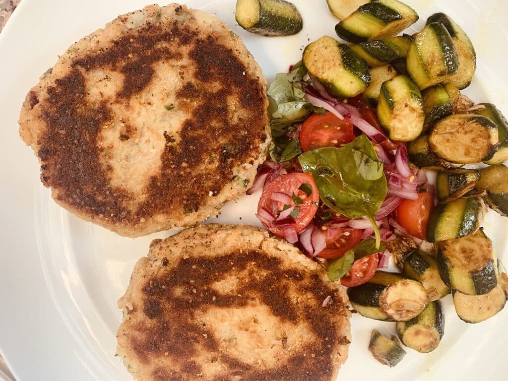 Spicy fish cakes with salsa and garlic zucchini