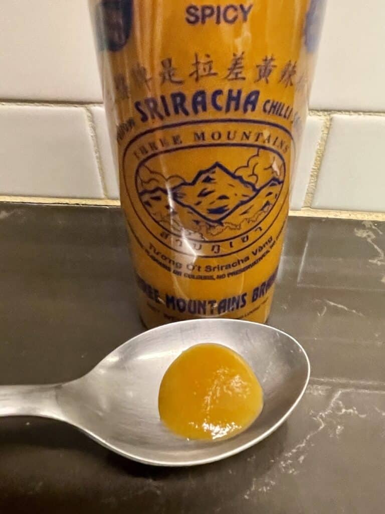 Three Mountains Yellow Sriracha on a spoon
