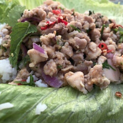 Close-up of larb isaan, served with Jasmine rice and greens
